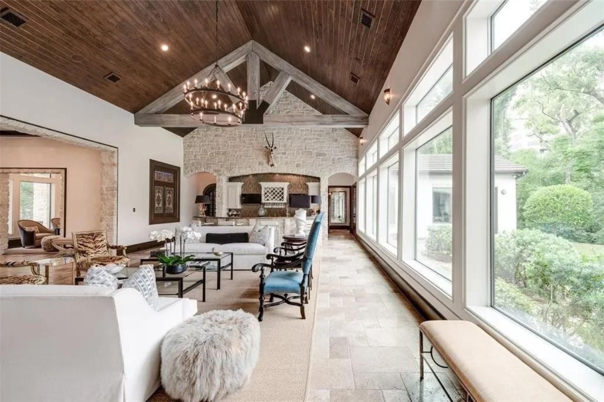 A great room with a vaulted ceiling, chandelier, living area, and kitchen.
