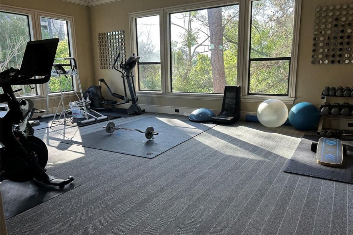 A home gym with windows and gym equipment.