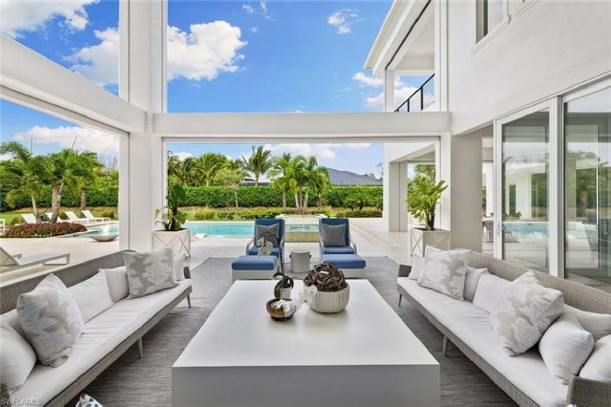 A living room with windows, couches, chairs, and a center table.