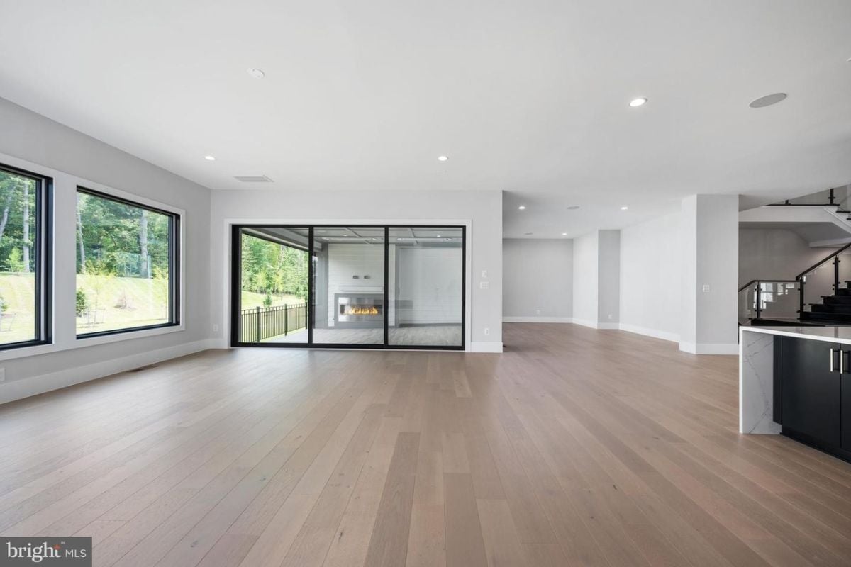 A living room with windows and a wooden floor.