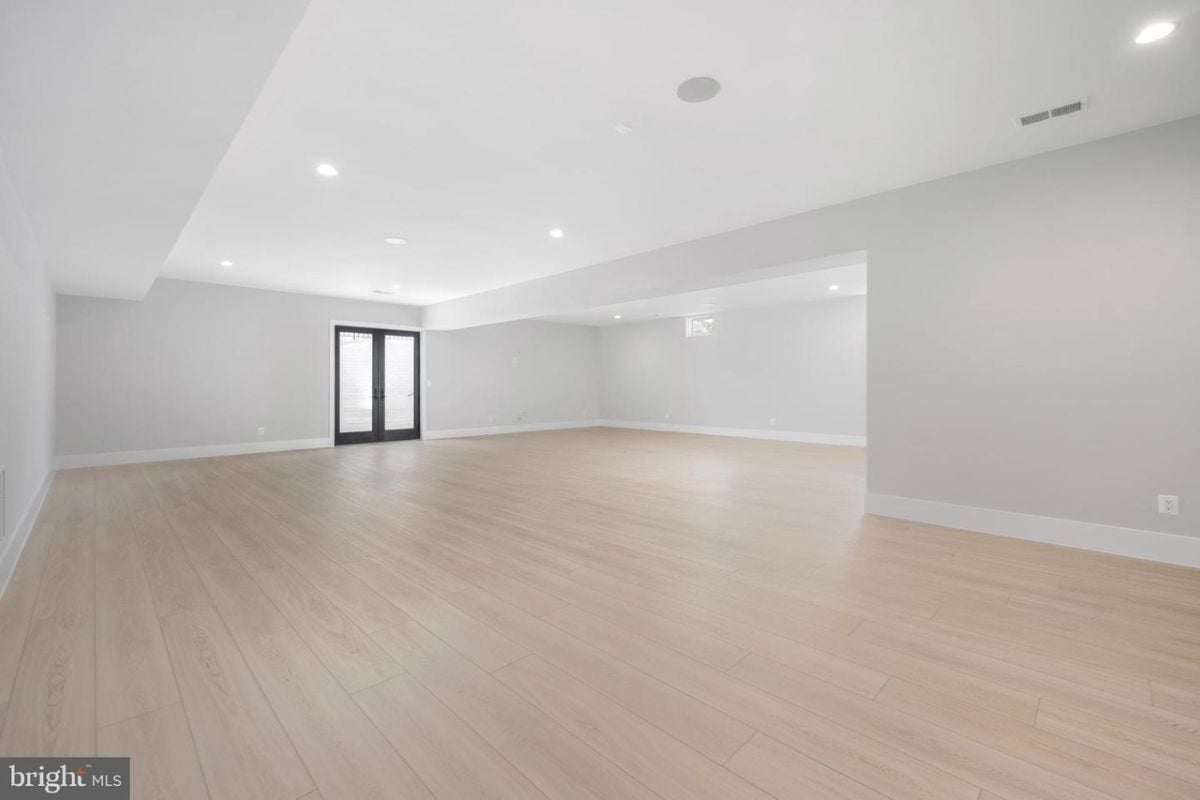 A living room with windows and a wooden floor.