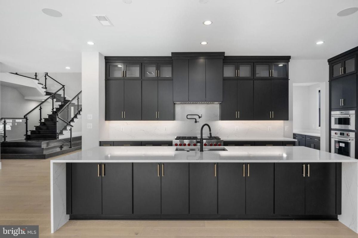 A kitchen with countertops, cabinets, sink, and kitchen appliances.
