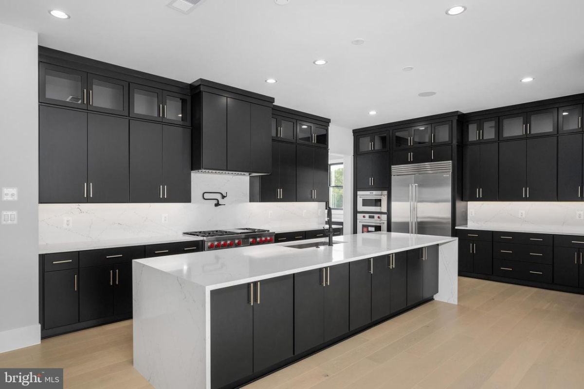 A kitchen with countertops, cabinets, sink, and kitchen appliances.