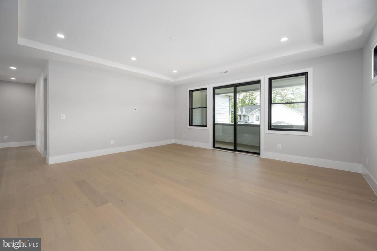 A bedroom with a window and wooden floor.