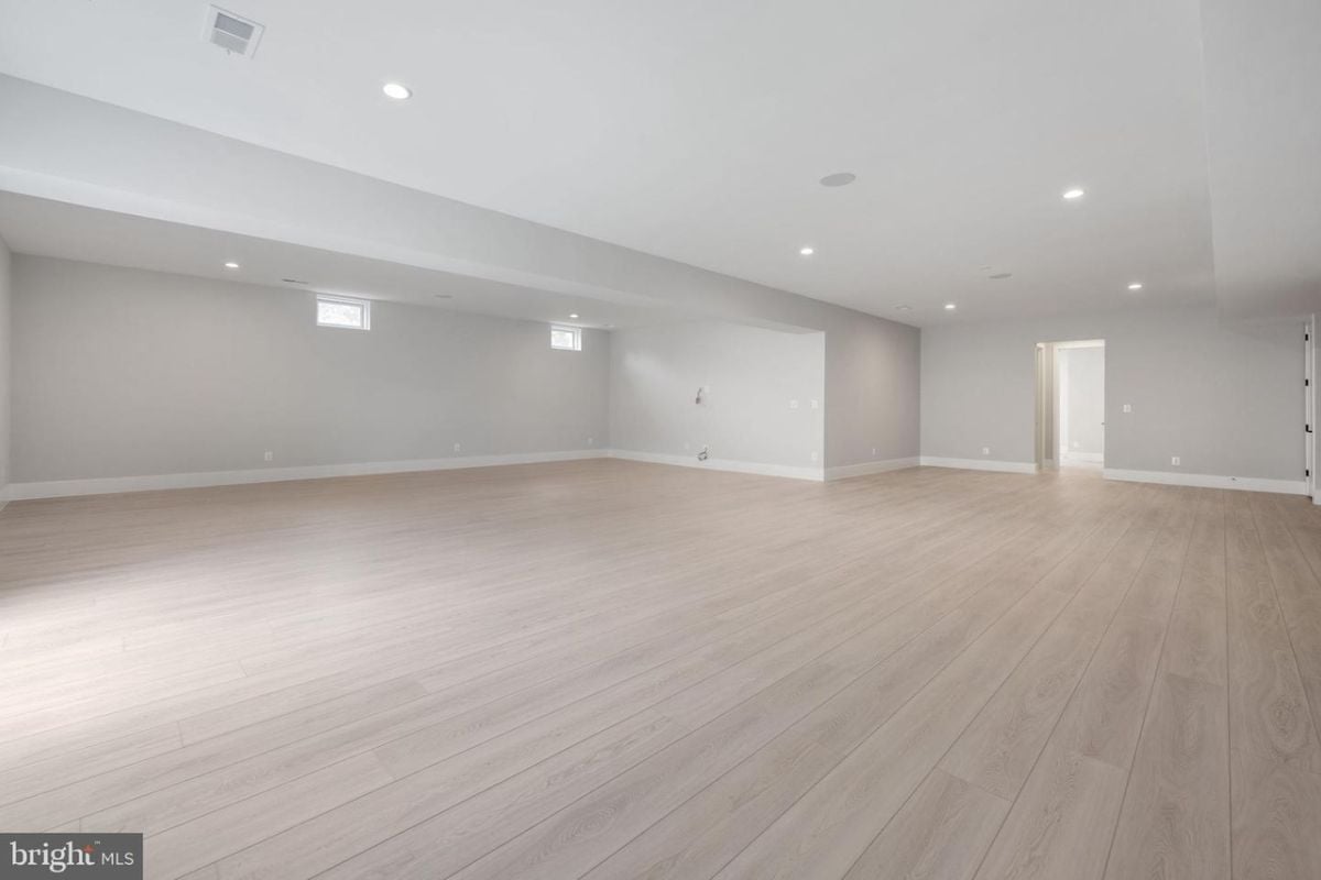 A living room with windows and a wooden floor.