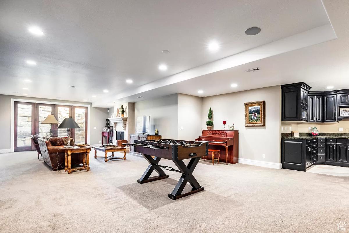 Recreational room with carpet flooring and custom lighting.