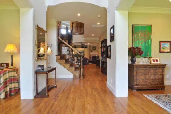 Foyer with a wooden console table, an archway, and a staircase leading to the secondary bedrooms.