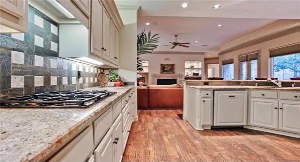 The kitchen includes granite countertops, and a built-in cooktop.