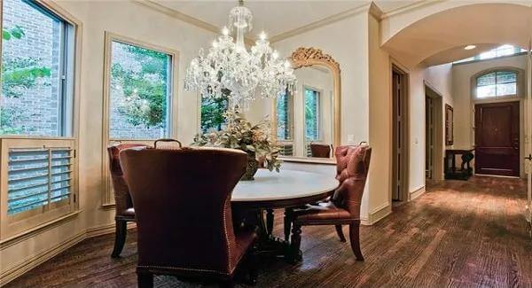 Breakfast nook with a bay window and a round dining set illuminated by a crystal chandelier.
