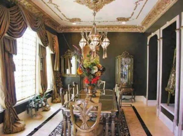 Dining room with an 8-seated dining set and a warm chandelier that hangs from the gilded ceiling.