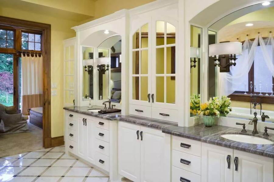 Primary vanity with two sinks and white cabinets.