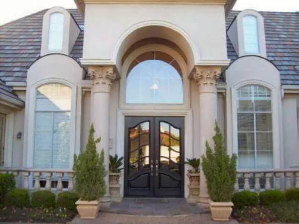 Front entry with a French front door topped by a large arched transom.