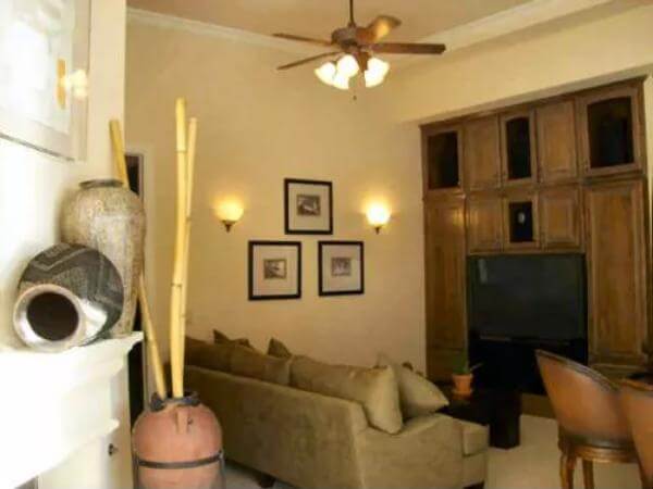 Game room with a leather sofa and a TV above the fireplace