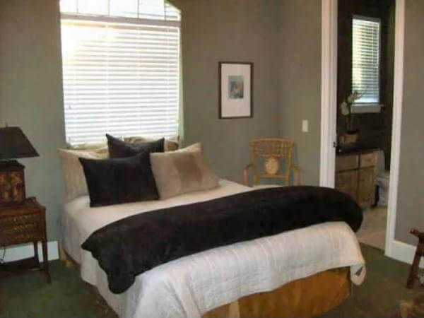 Bedroom with an wooden bed and an ensuite bathroom.