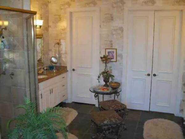 Primary bathroom with a white vanity and a tiled shower.