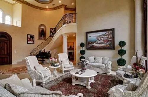 Living room with white chairs and a matching round table over the vintage area rug.