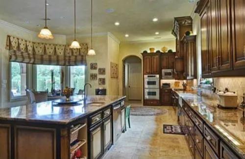 Kitchen with dark wood cabinets and a breakfast island fitted with a sink.