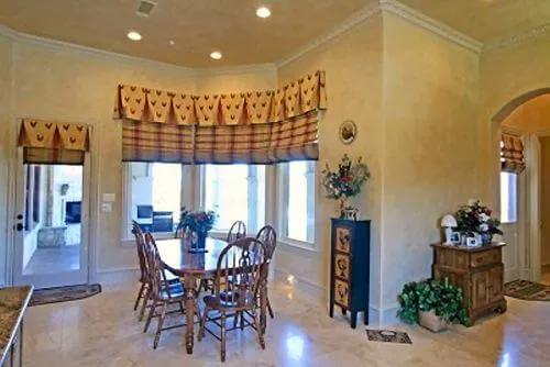 Breakfast nook with a wooden dining set against the bay window.