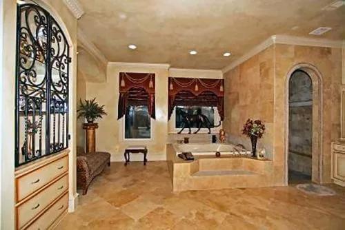 Primary bathroom with a chaise sofa, a bathtub, and a walk-in shower.