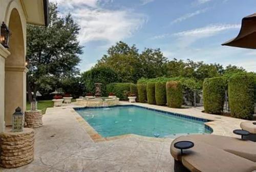 Pool area adorned by manicured shrubs.