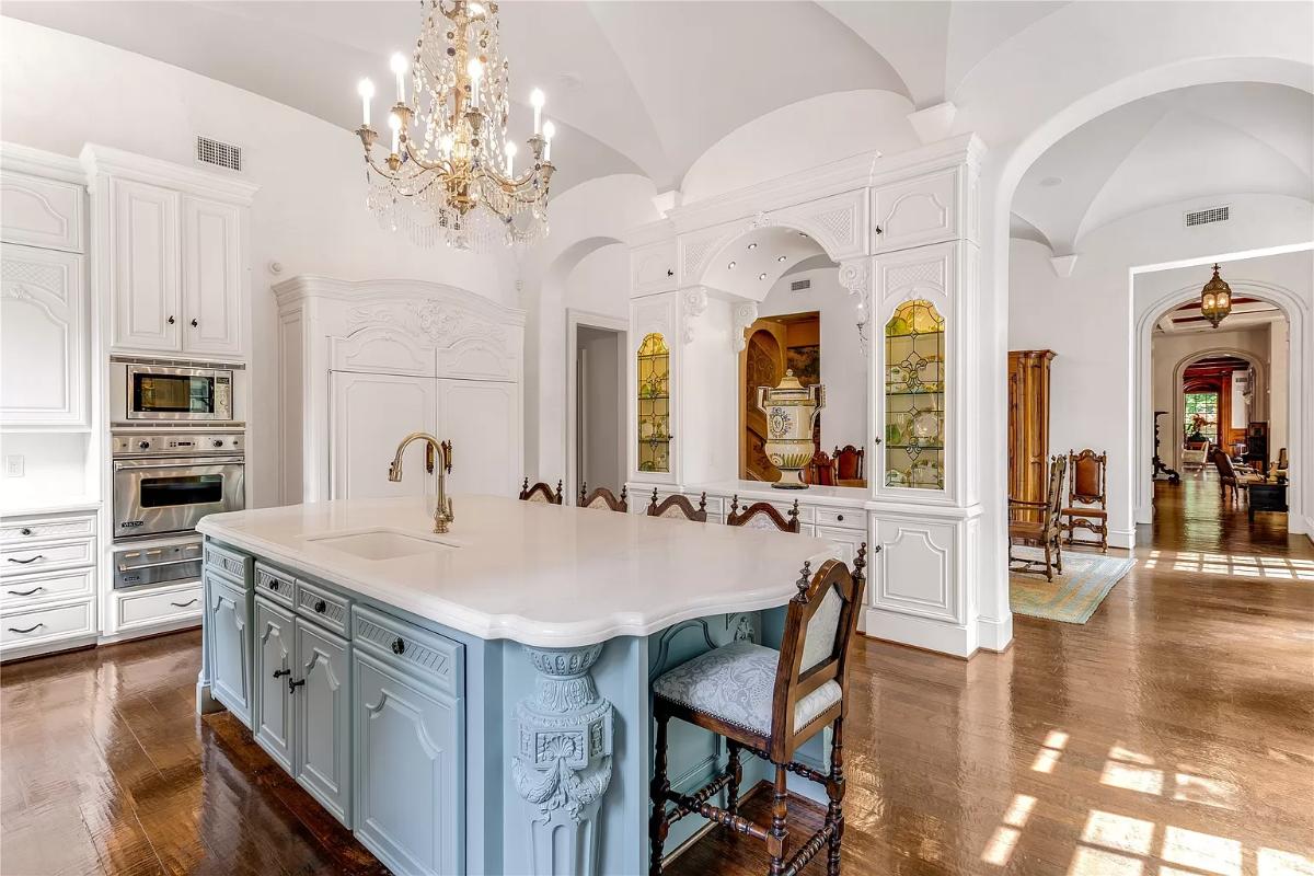 Kitchen with custom cabinetry, a counter breakfast bar and a chandelier.