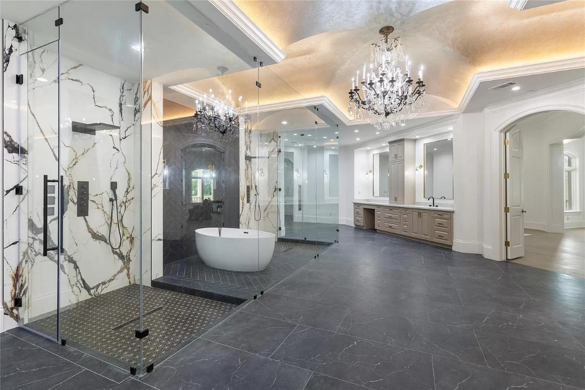 Bathroom with a chandelier, soaking tub and a walk-in shower.