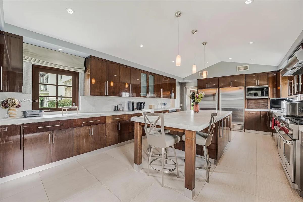 Kitchen with a custom cabinetry, a counter breakfast bar and a center island prep area.