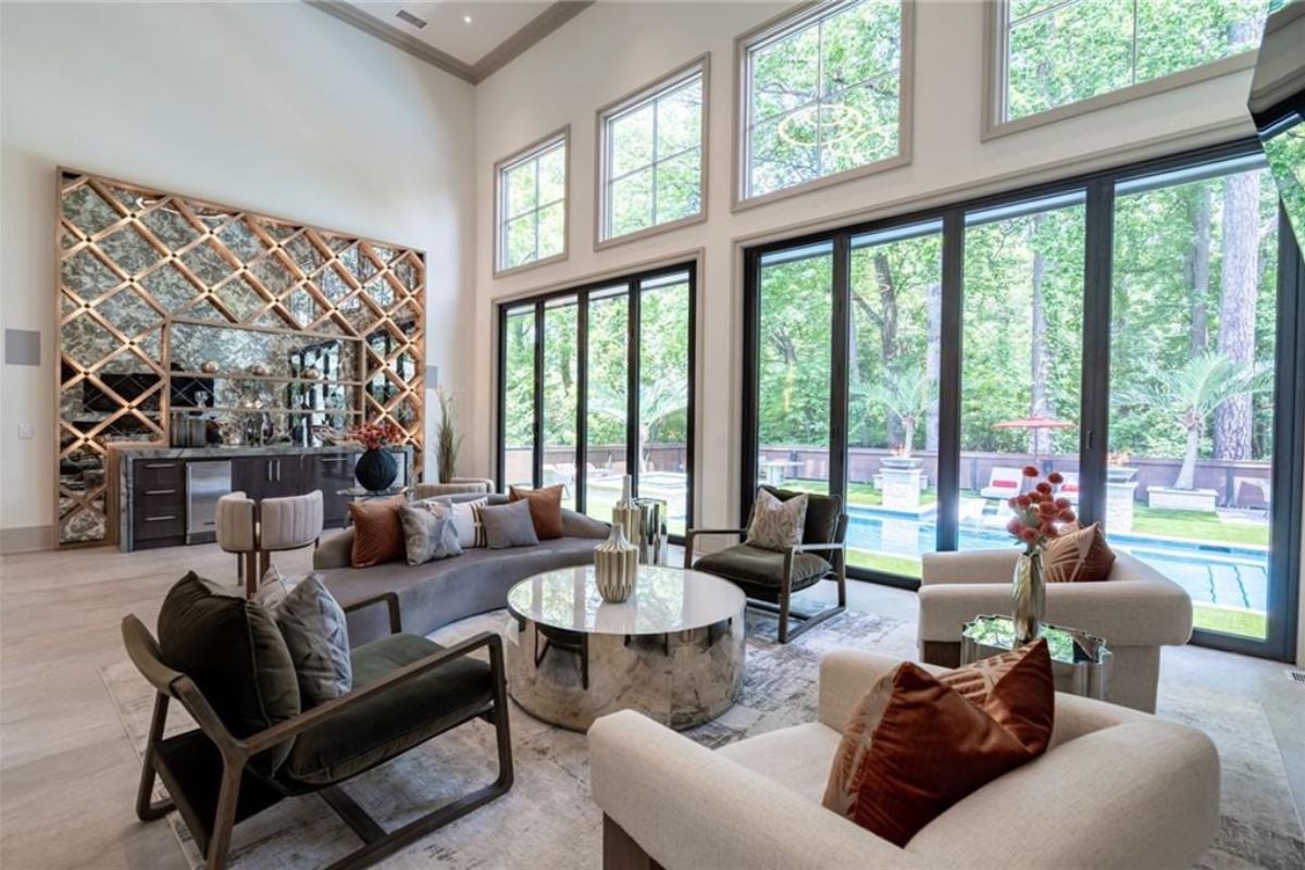 A living room with windows, a couch, chairs, and a coffee table.