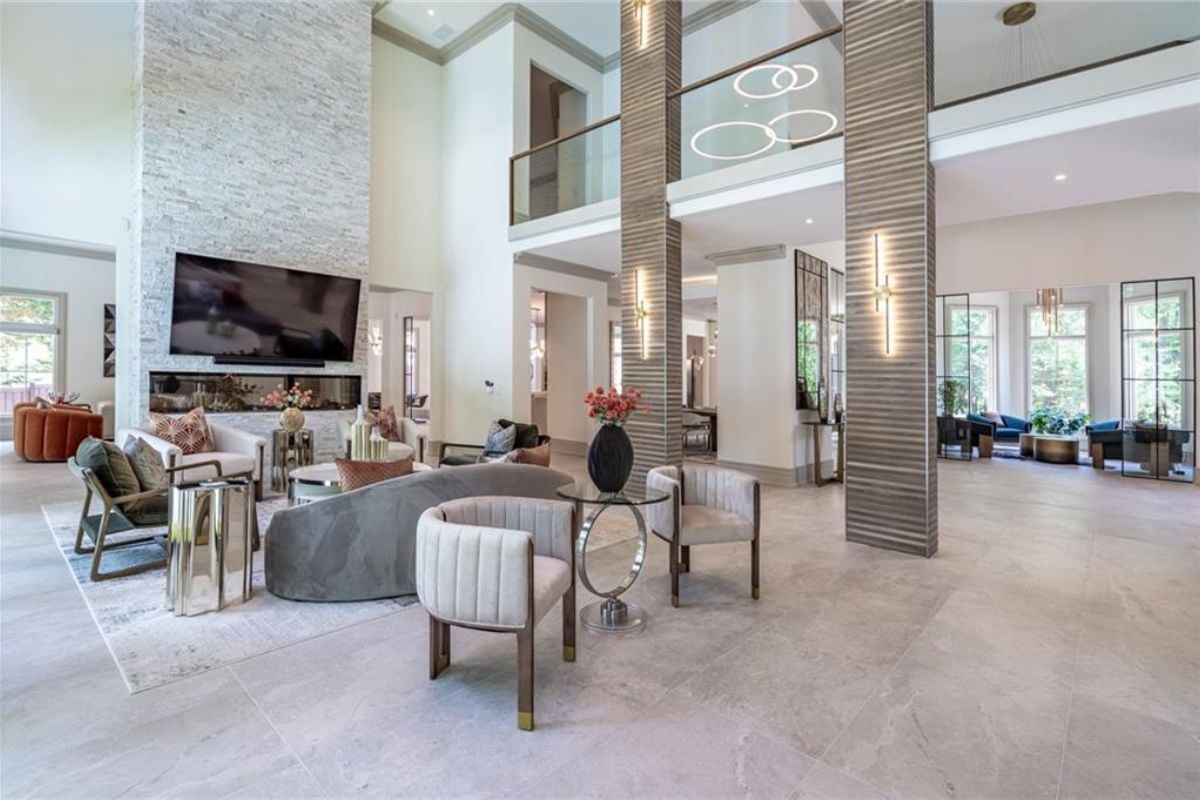 A living room with a TV, a fireplace, couches, chairs, and a coffee table.