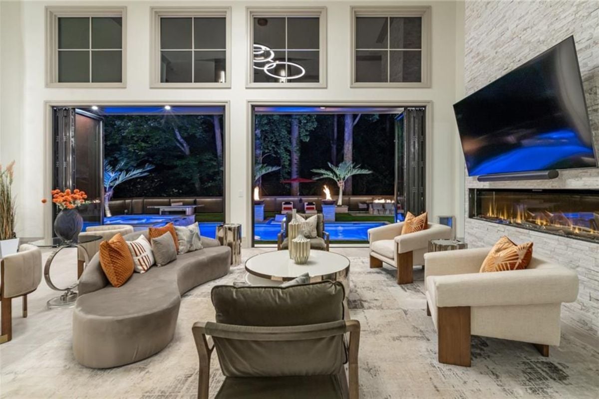 A living room with a TV, a fireplace, couches, chairs, and a coffee table.