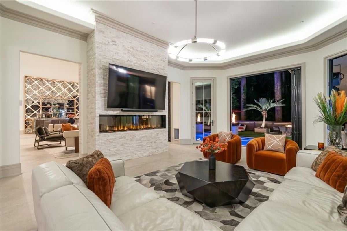 A family room with a TV, a fireplace, a rug, a couch, chairs, and a coffee table.