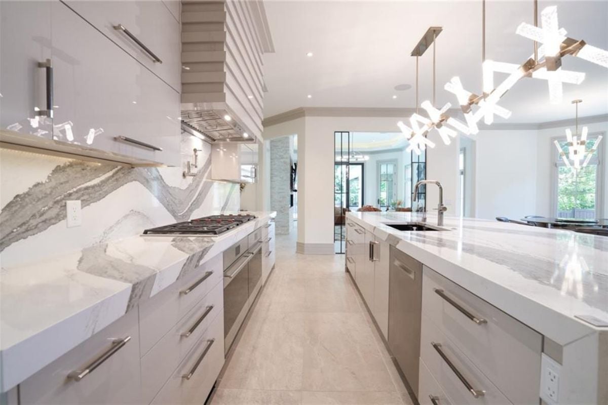 A kitchen with countertops, a sink, cabinets, and a stove.