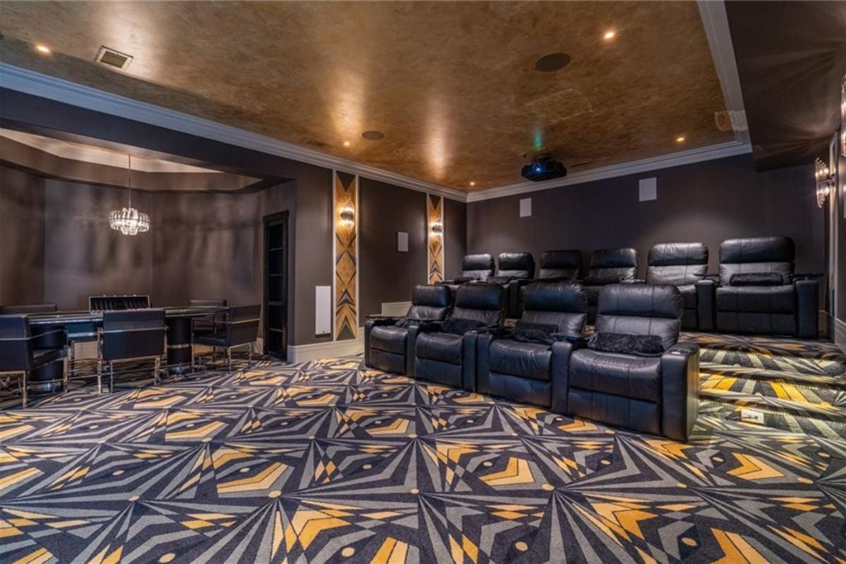 A home theater with a rug and cinema chairs.