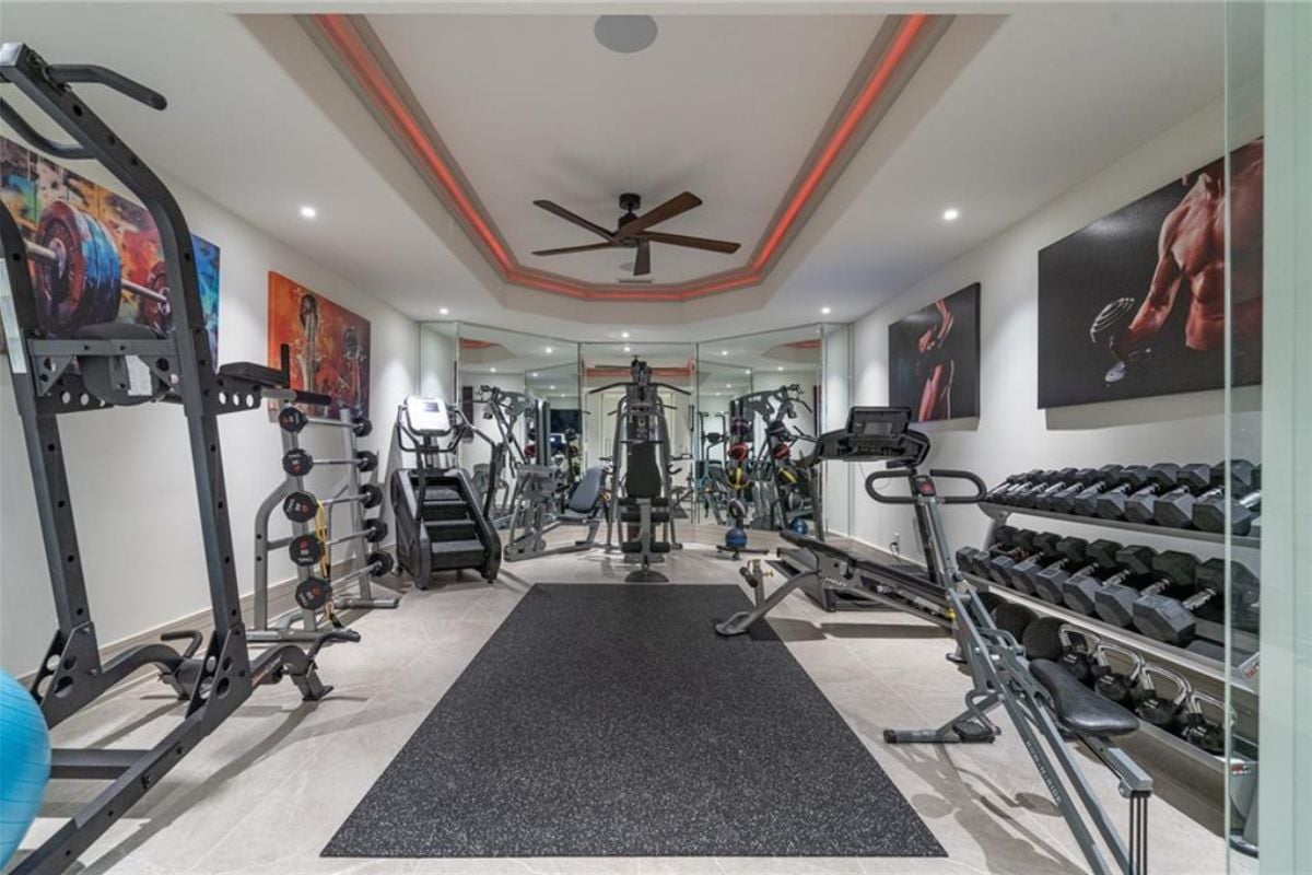 A home gym with a ceiling fan and gym equipment.