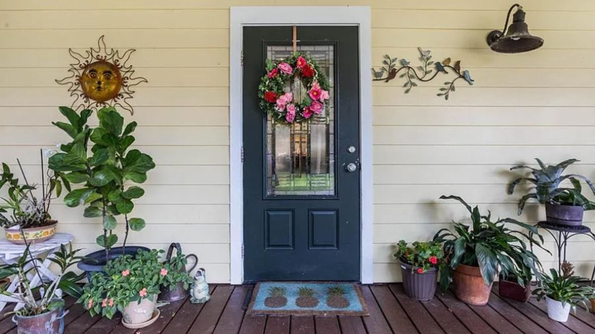 A front entry of the house with potted plants.
