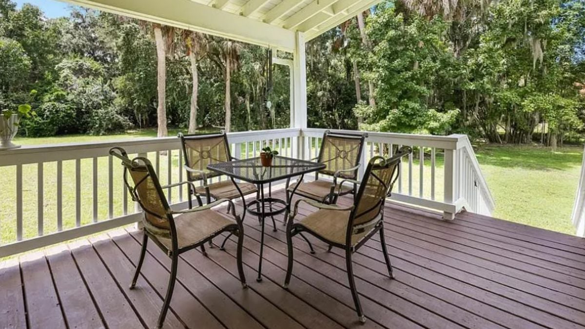 A deck with a table surrounded by chairs.