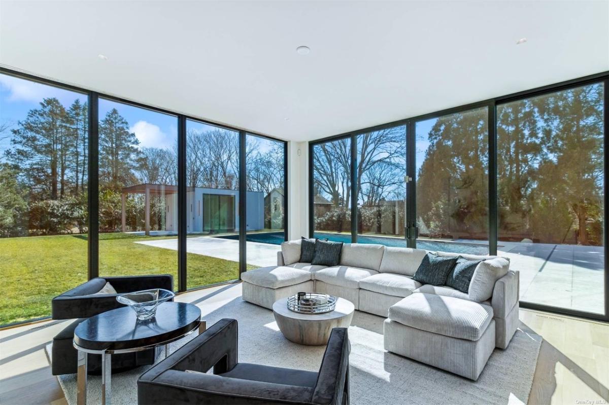 Living room with couches and glass walls.
