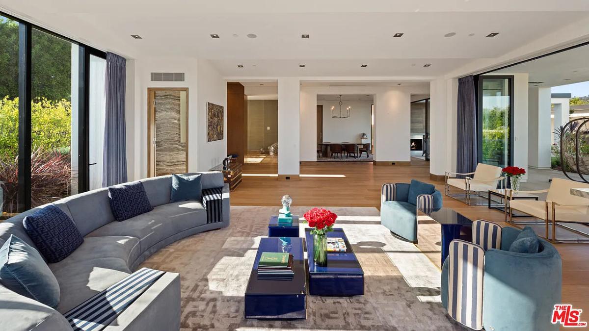 Living room with couches and hardwood floors.