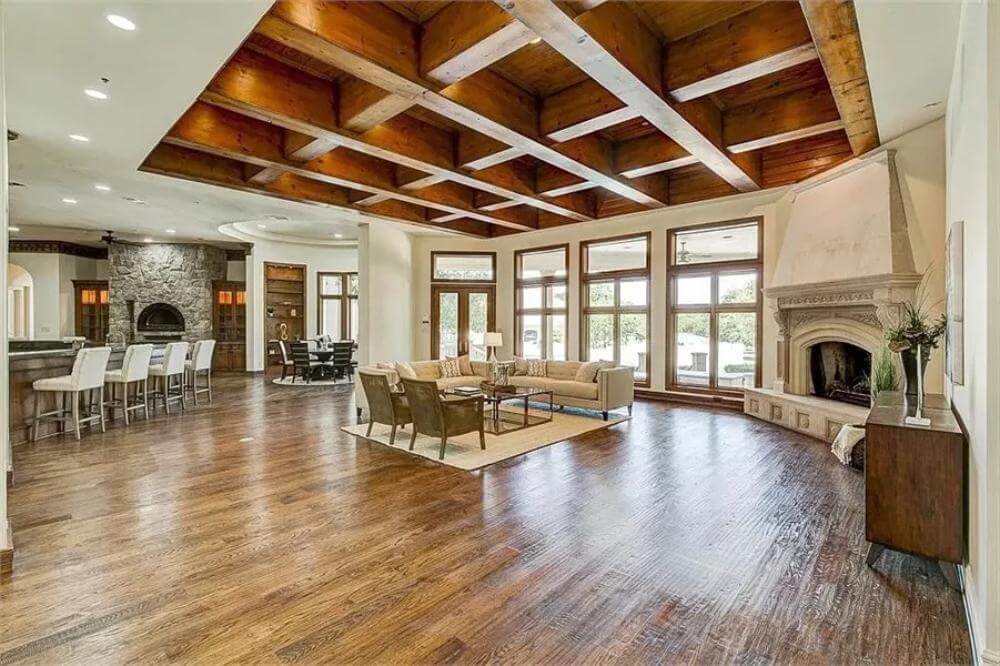 spacious open-concept living area with exposed wood beams