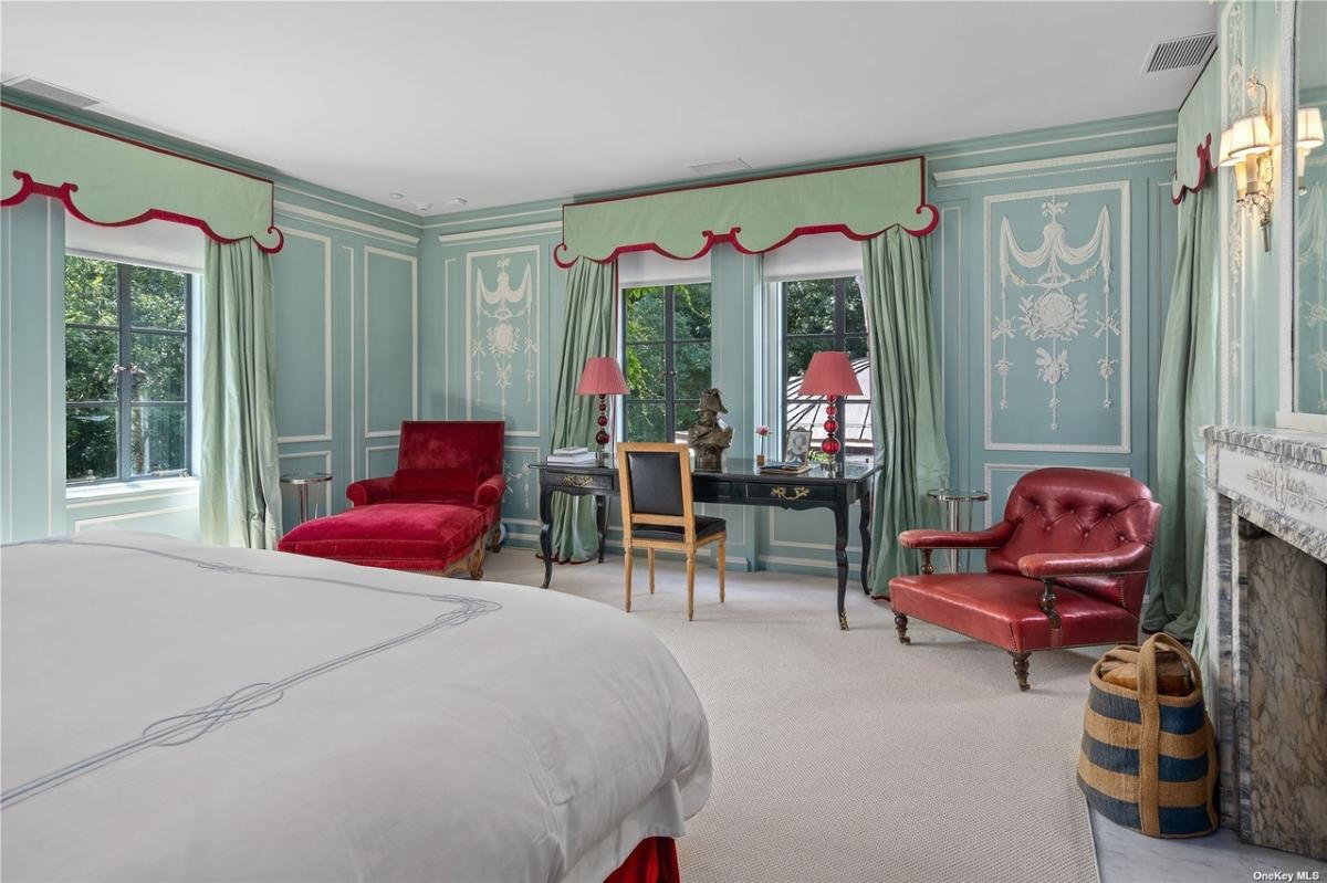 Bedroom with carpet flooring and a fireplace.