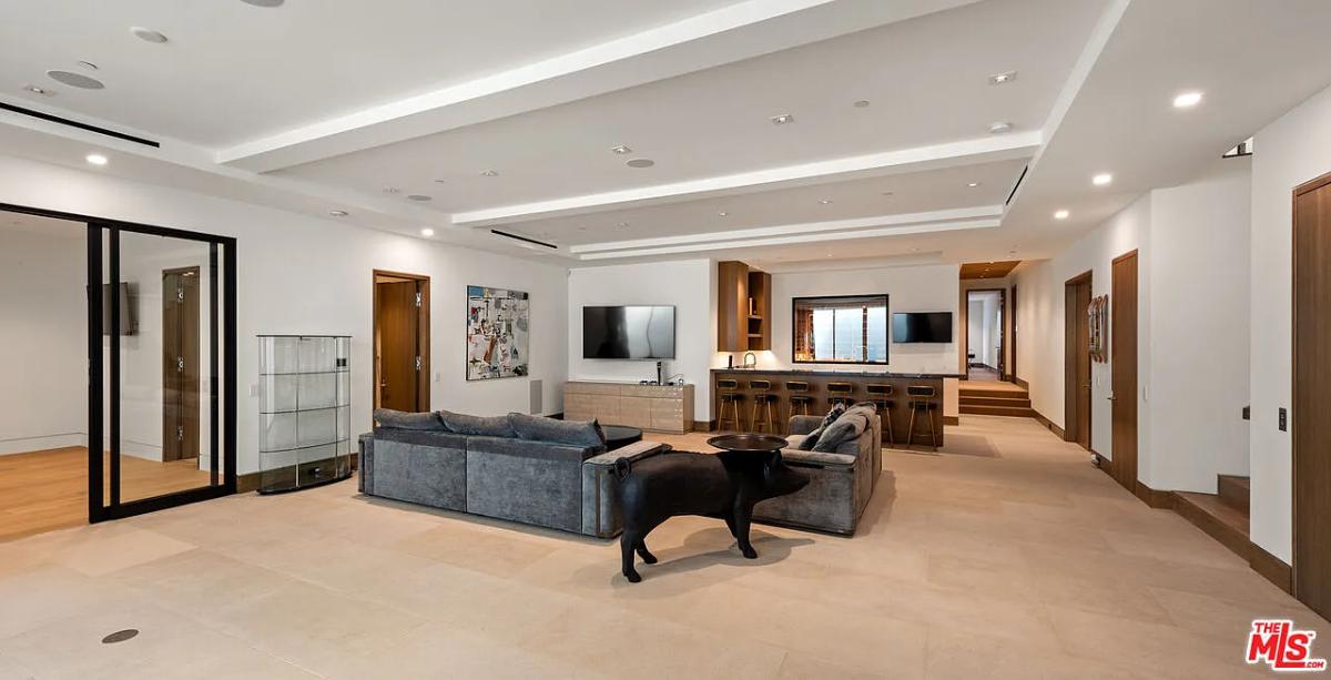Recreation room with couches, a TV and a bar.