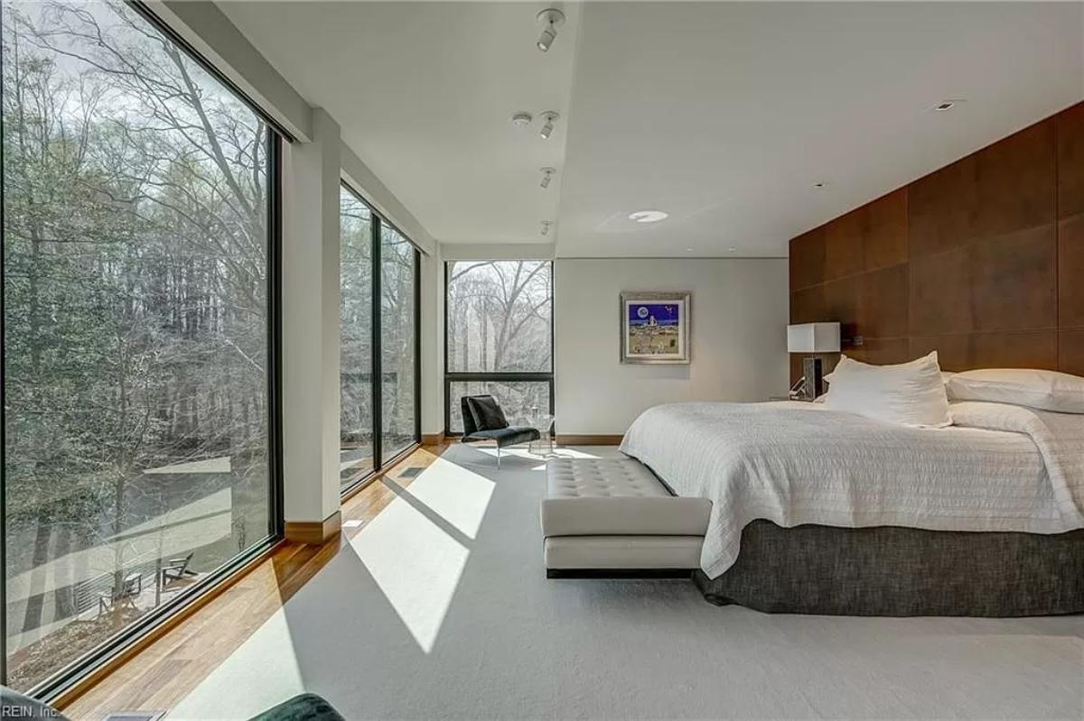Bedroom with a large bed and glass walls.