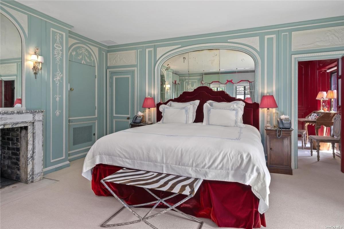 Bedroom with carpet flooring and a fireplace.