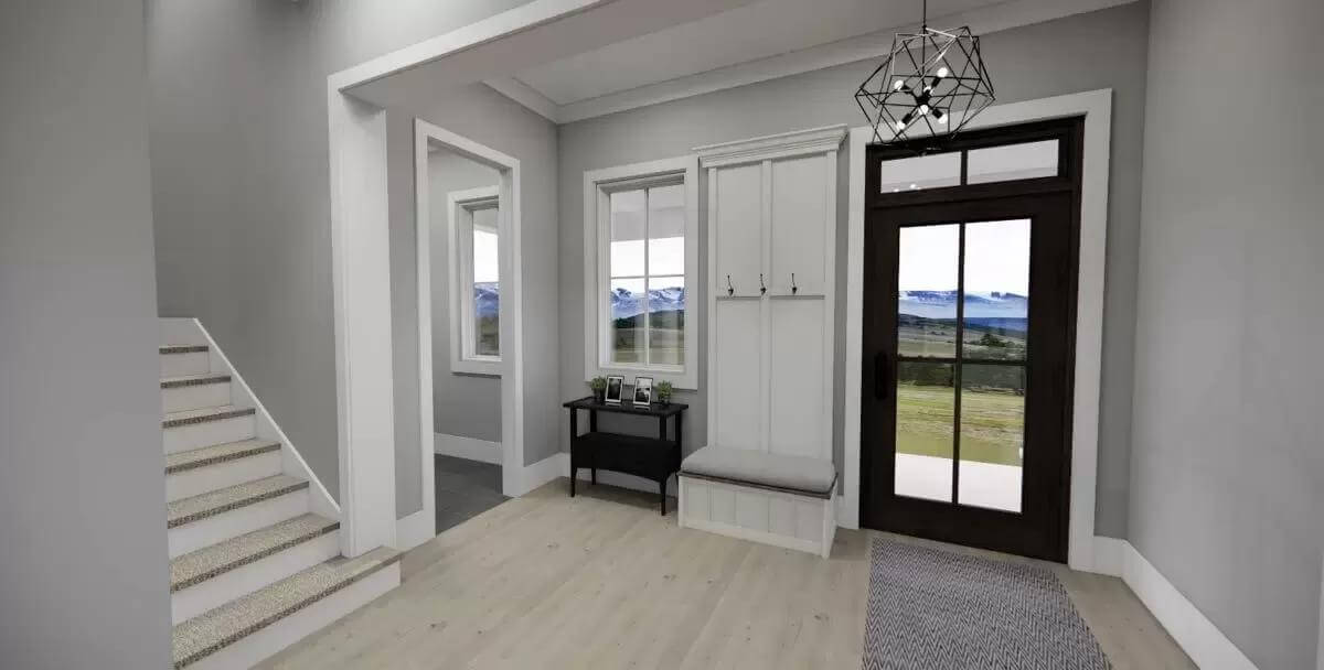 Foyer with a glazed front door, a cushioned bench, and coat hooks.