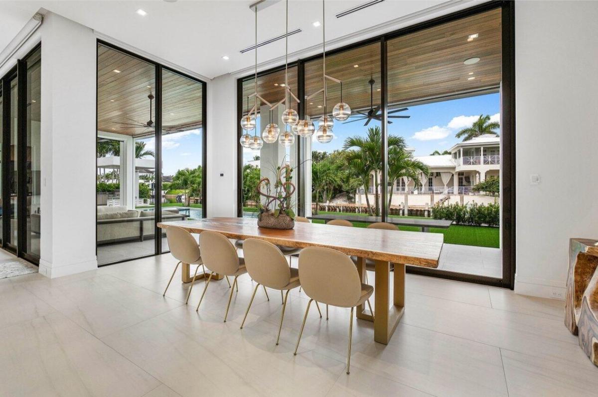 Dining room with a large wood table and glass walls.