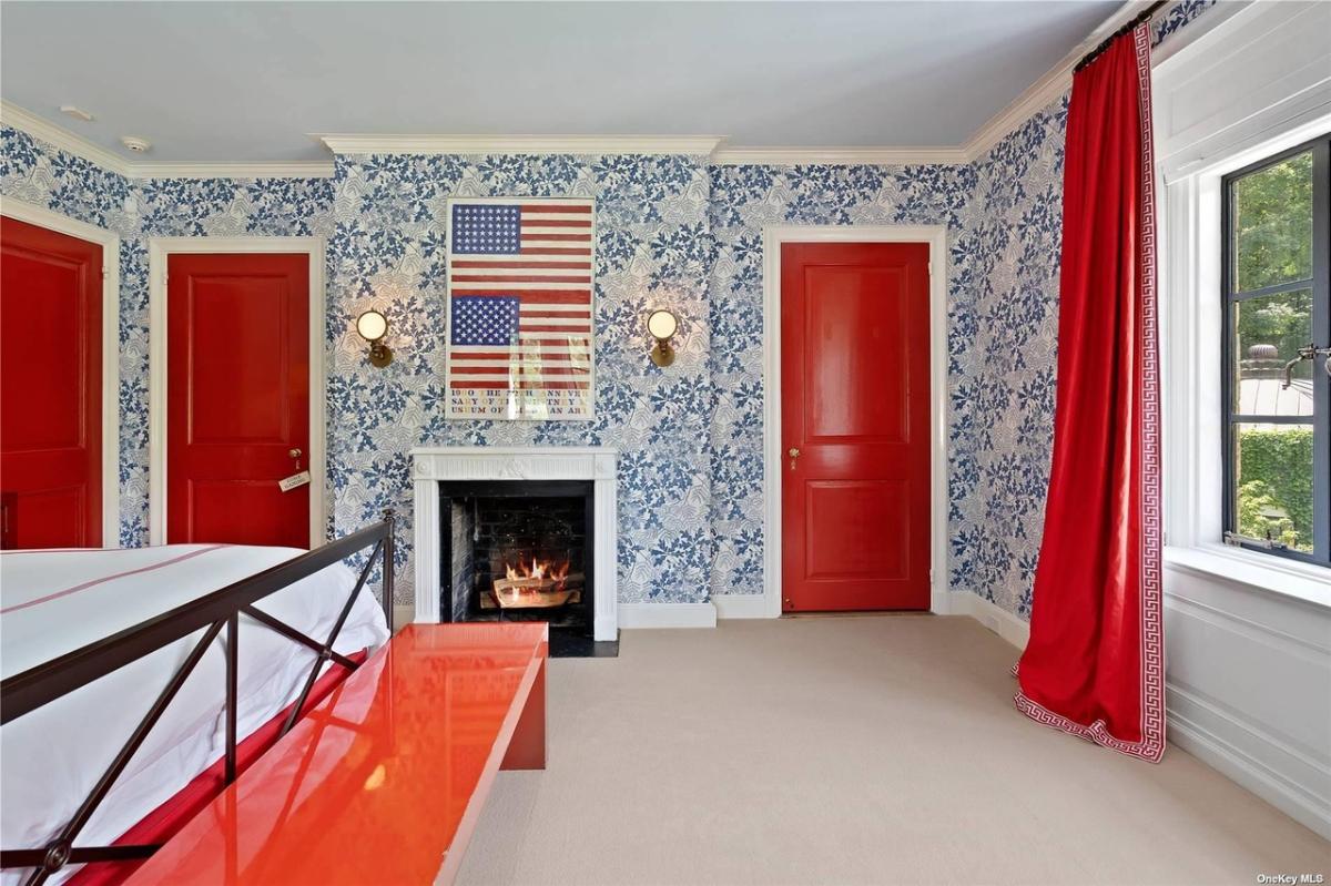 Bedroom with carpet flooring and a fireplace.