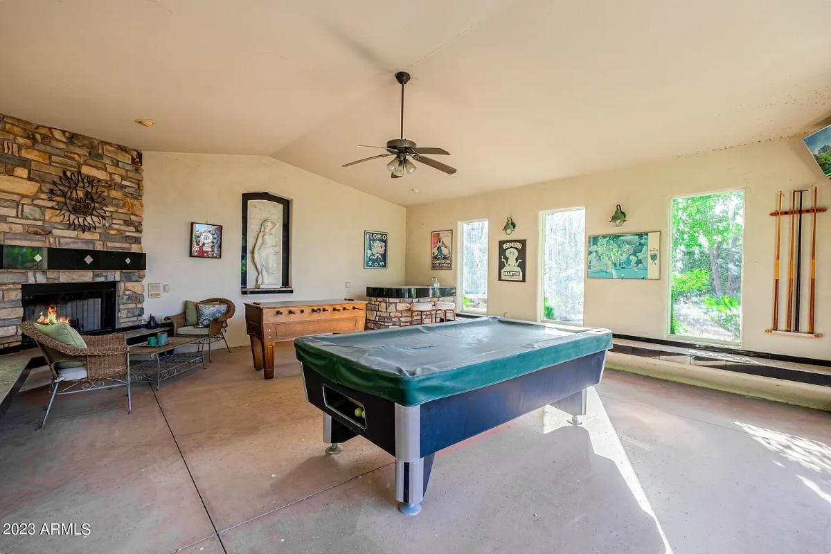 Recreation room with a billiards table and a fireplace.