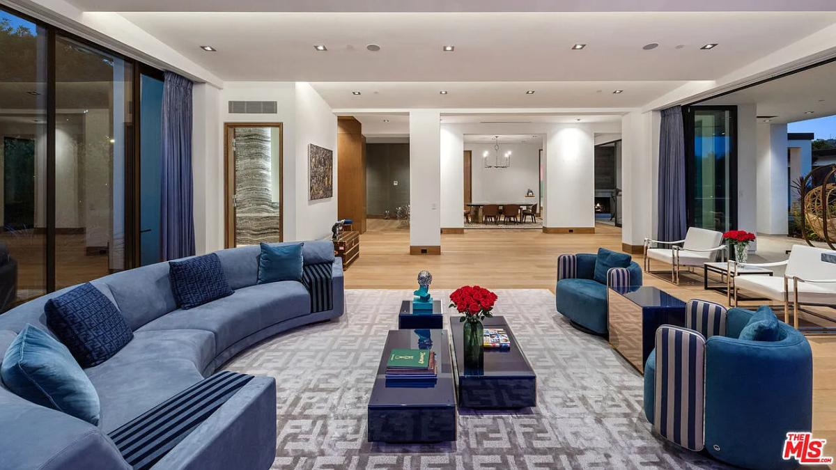 Living room with couches and hardwood floors.