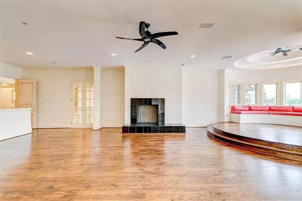 sunken entertainment room with fireplace and bay windows