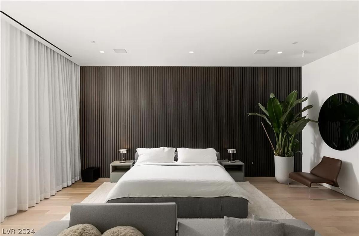 Bedroom with a large bed and hardwood floors.